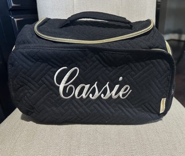 A black bag with the name cassie on it.