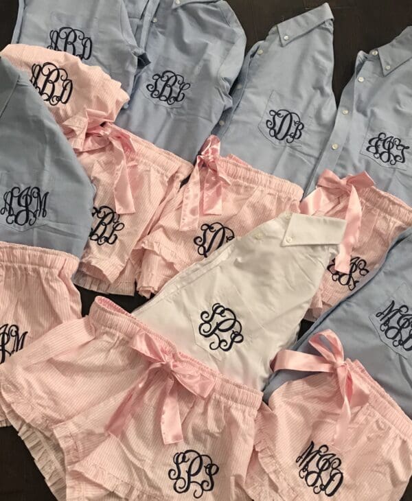 A bunch of monogrammed pajamas are laying on the floor