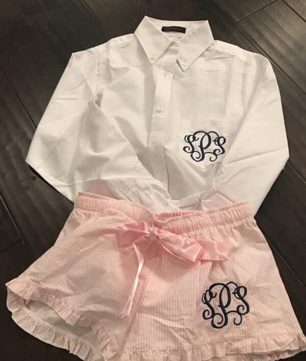 A white shirt and pink shorts with initials on them.