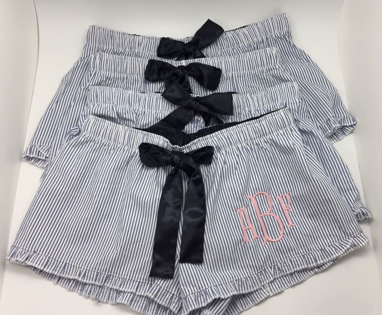 A group of four women 's shorts with black bows.