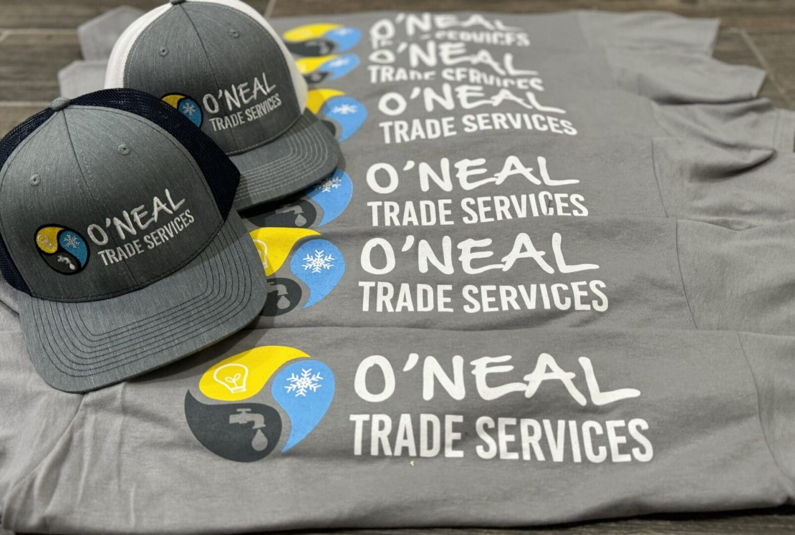 A group of hats and t-shirts with o ' neal trade services logo.