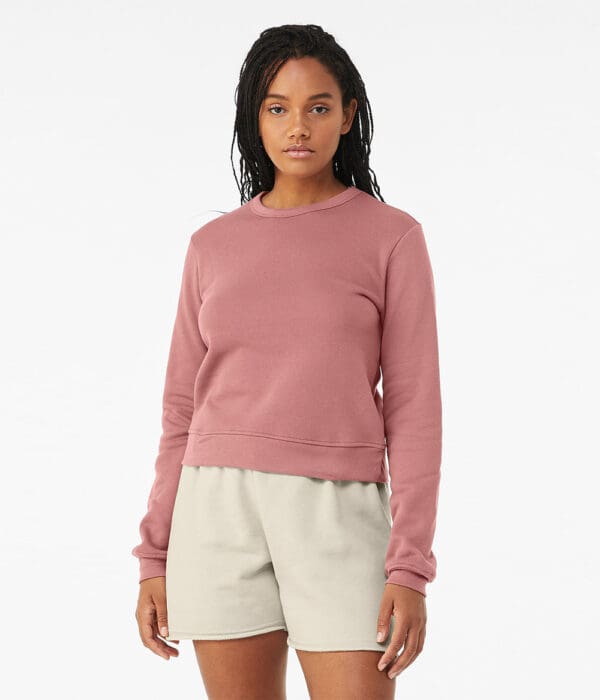 A woman wearing white shorts and pink sweater.