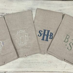 A group of four towels with monogrammed initials.