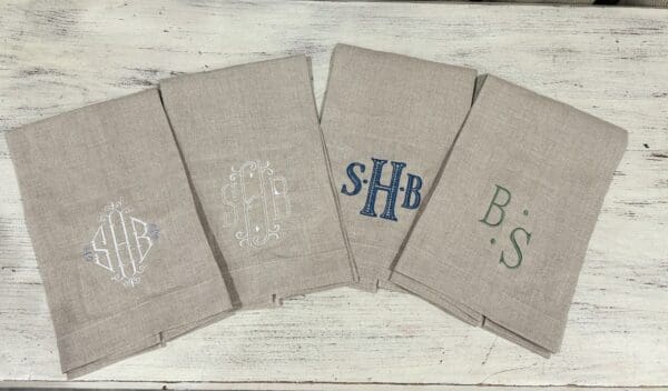 A group of four towels with monogrammed initials.