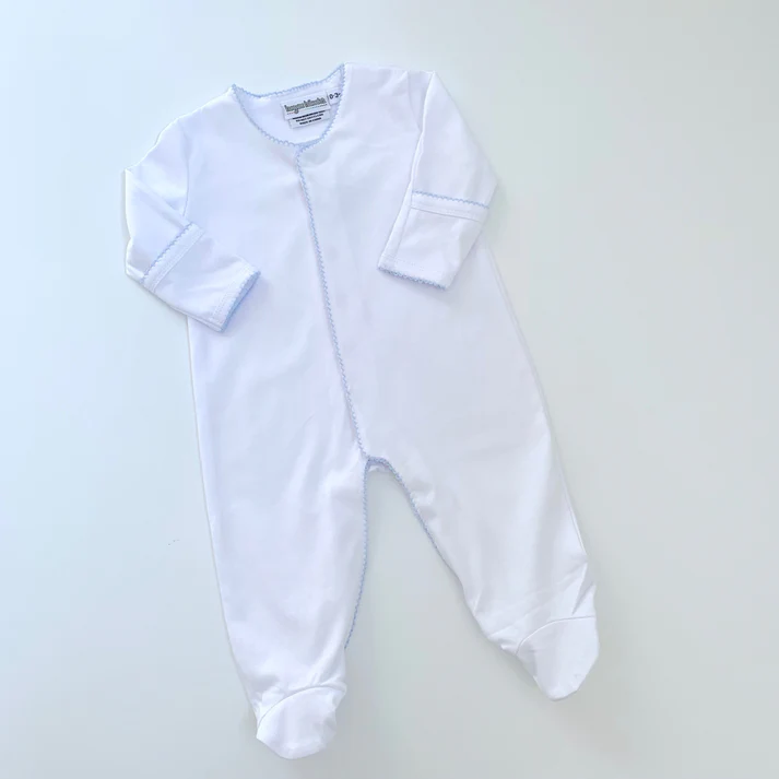 A white baby 's outfit is laying on the floor.