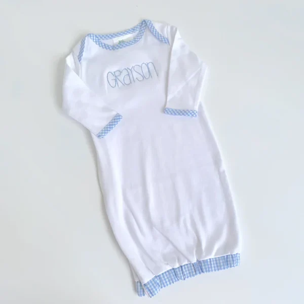 A white and blue baby gown on top of a table.