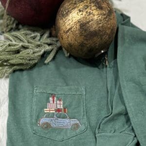 Green shirt with Christmas car embroidery.