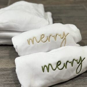 White sweatshirts with "Merry" embroidered.